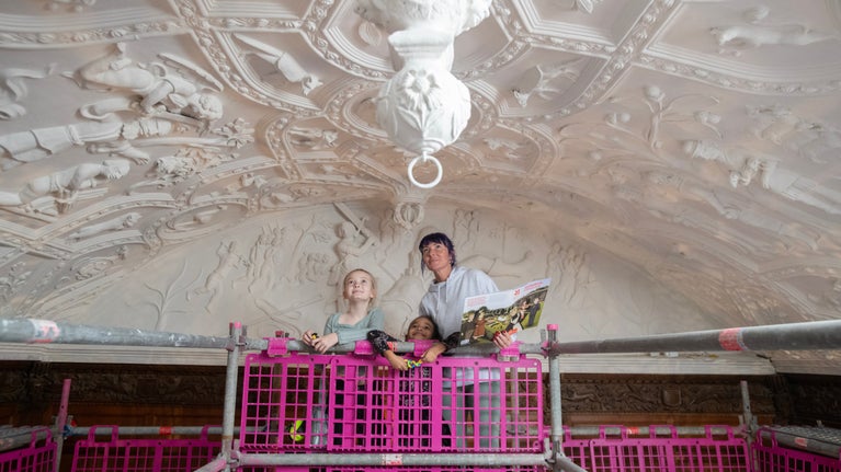 A family on the scaffold enjoying the Long Gallery ceiling after conservation work at Lanhydrock in Cornwall